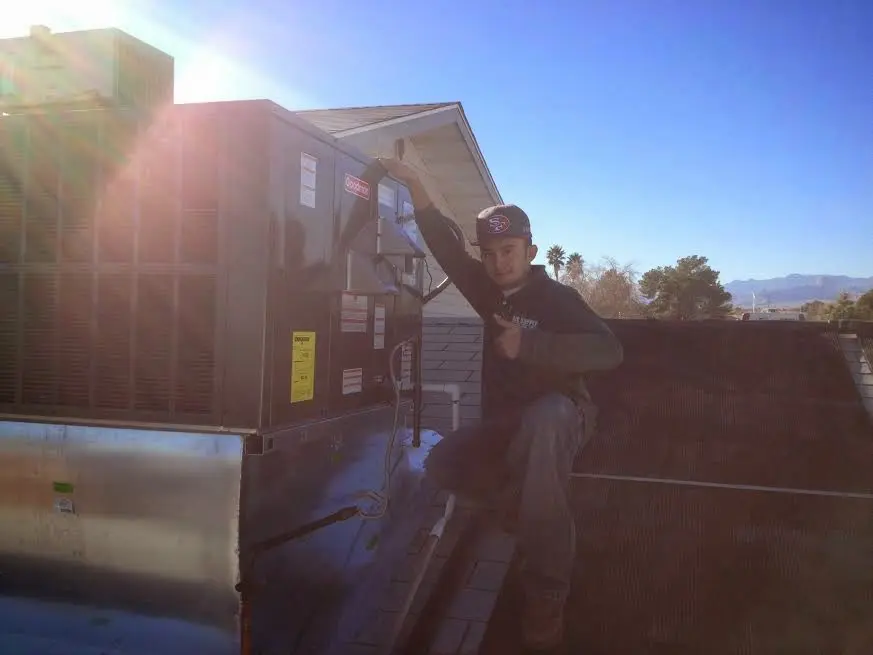 HVAC technician performing AC Tune-Up on a rooftop unit in Storm Lake